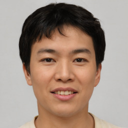 Joyful asian young-adult male with short  brown hair and brown eyes