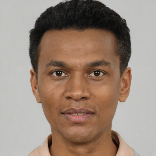 Joyful black young-adult male with short  black hair and brown eyes