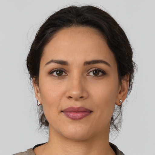 Joyful latino young-adult female with medium  brown hair and brown eyes