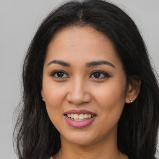 Joyful latino young-adult female with long  brown hair and brown eyes