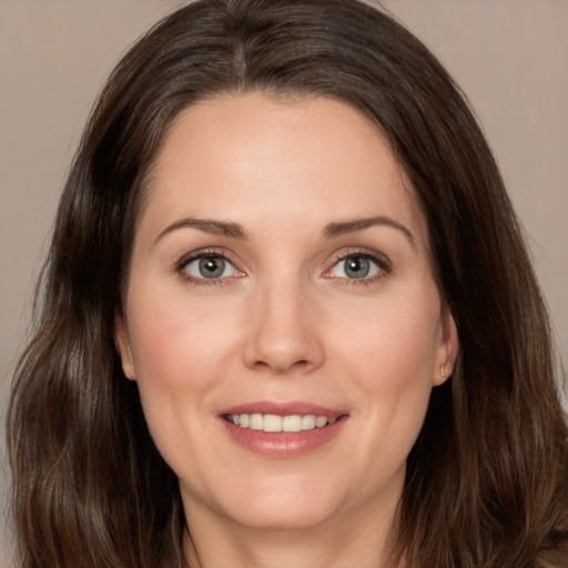 Joyful white adult female with long  brown hair and brown eyes