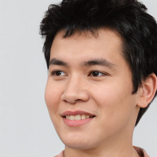 Joyful asian young-adult male with short  black hair and brown eyes