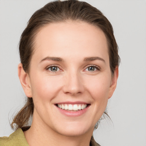 Joyful white young-adult female with medium  brown hair and grey eyes