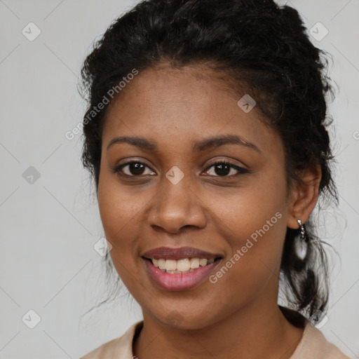 Joyful black young-adult female with long  brown hair and brown eyes