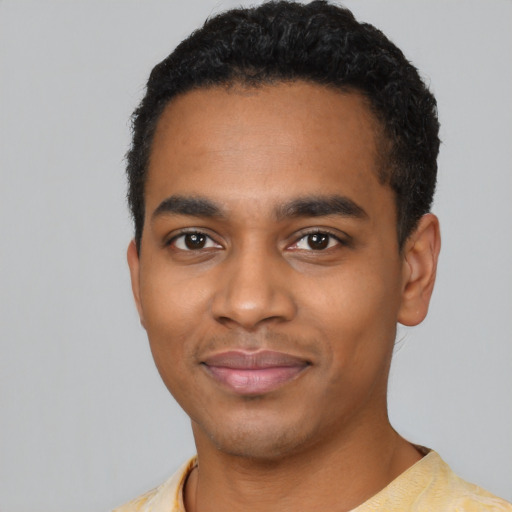 Joyful black young-adult male with short  black hair and brown eyes