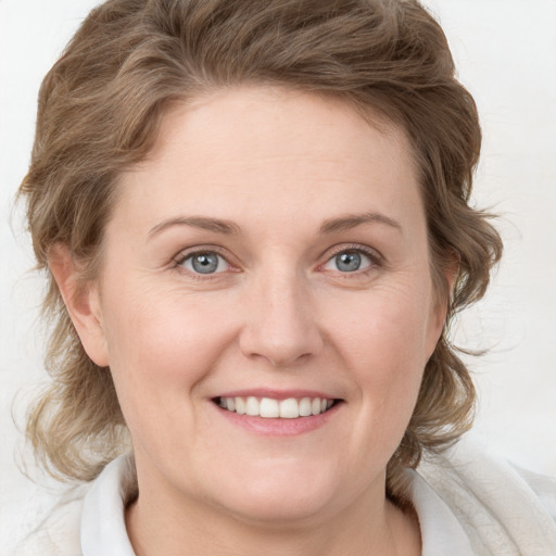 Joyful white young-adult female with medium  brown hair and blue eyes