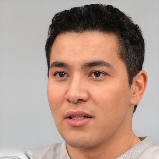 Joyful asian young-adult male with short  black hair and brown eyes