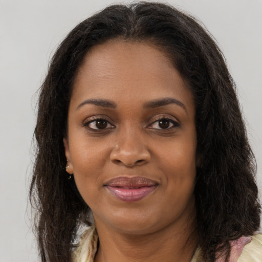 Joyful black young-adult female with long  brown hair and brown eyes