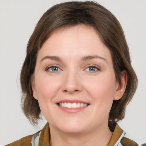 Joyful white young-adult female with medium  brown hair and grey eyes