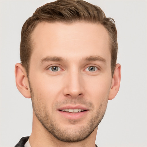 Joyful white young-adult male with short  brown hair and grey eyes