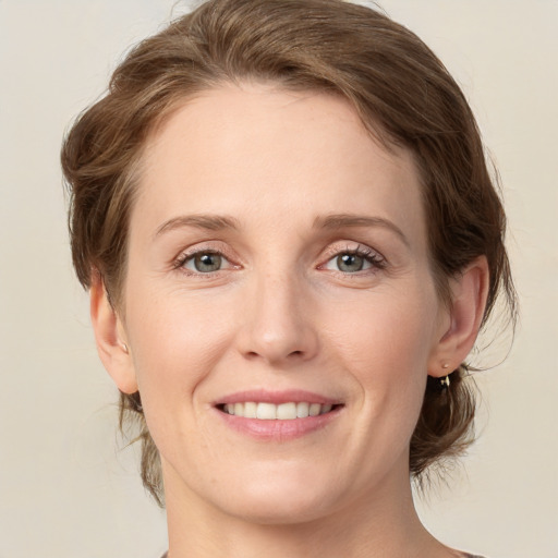 Joyful white young-adult female with medium  brown hair and green eyes