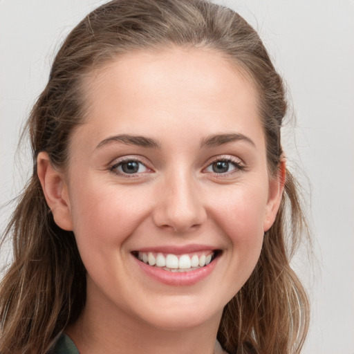 Joyful white young-adult female with long  brown hair and grey eyes