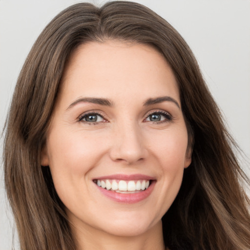 Joyful white young-adult female with long  brown hair and brown eyes