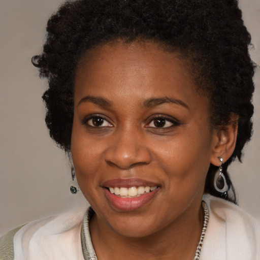 Joyful black young-adult female with long  brown hair and brown eyes