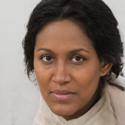 Joyful black adult female with long  brown hair and brown eyes