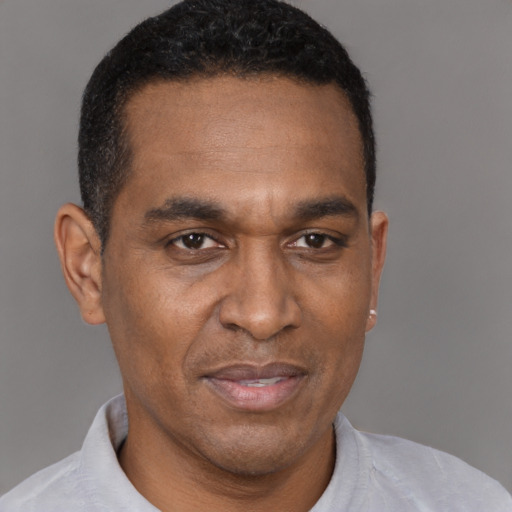 Joyful black adult male with short  black hair and brown eyes
