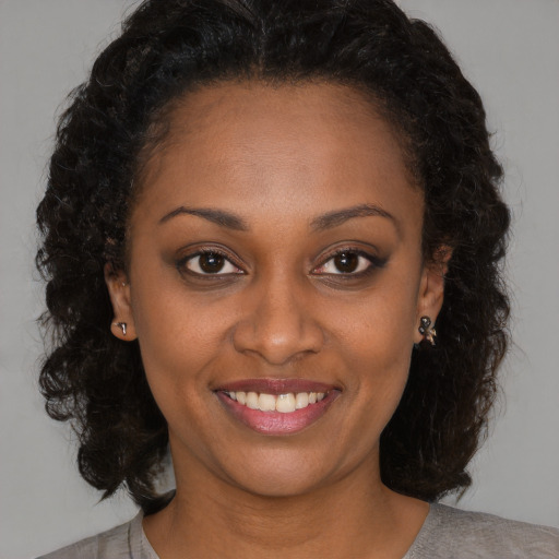 Joyful black young-adult female with medium  brown hair and brown eyes