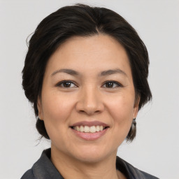 Joyful asian adult female with medium  brown hair and brown eyes