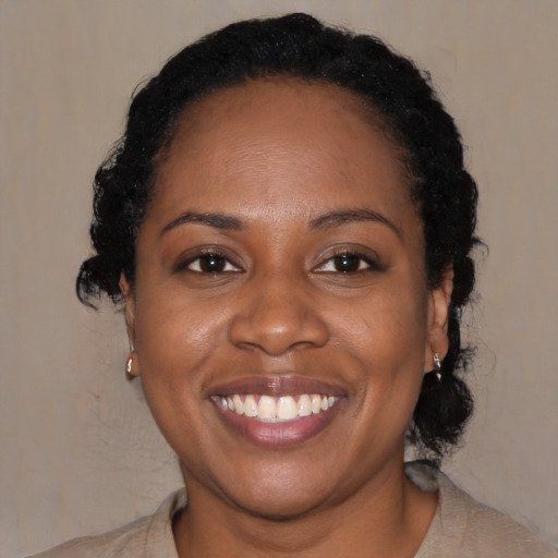 Joyful black young-adult female with medium  black hair and brown eyes