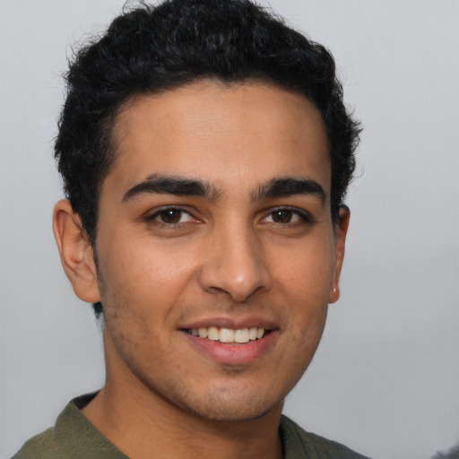 Joyful latino young-adult male with short  brown hair and brown eyes