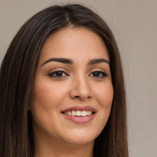 Joyful white young-adult female with long  brown hair and brown eyes