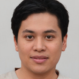 Joyful asian young-adult male with short  brown hair and brown eyes