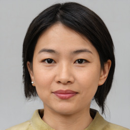 Joyful asian young-adult female with medium  brown hair and brown eyes