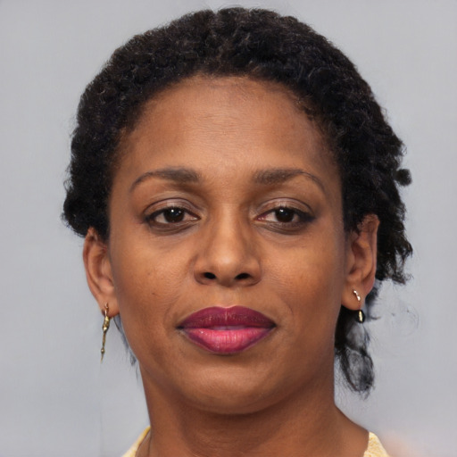 Joyful black adult female with short  brown hair and brown eyes