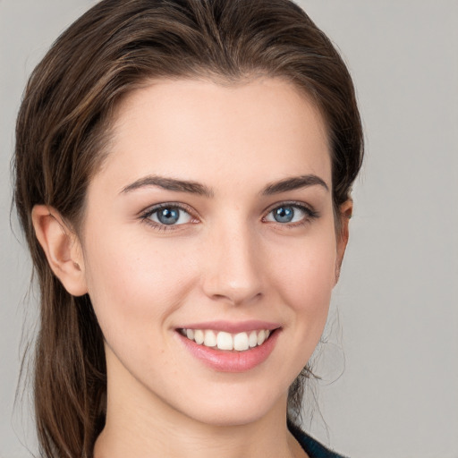 Joyful white young-adult female with long  brown hair and grey eyes