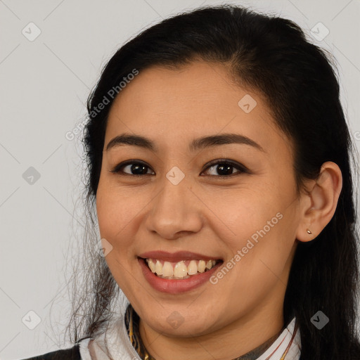 Joyful latino young-adult female with long  brown hair and brown eyes