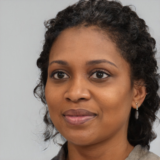 Joyful black young-adult female with medium  brown hair and brown eyes