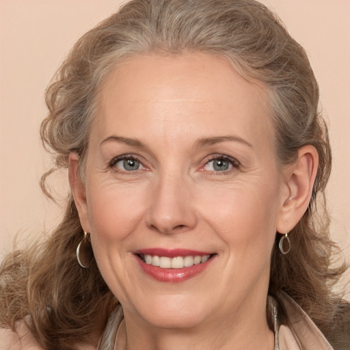 Joyful white adult female with medium  brown hair and grey eyes