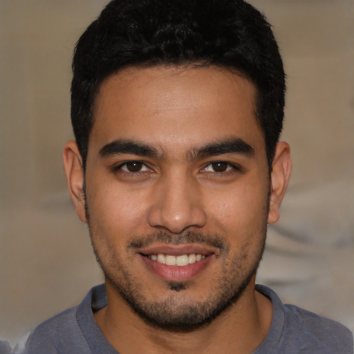 Joyful latino young-adult male with short  brown hair and brown eyes
