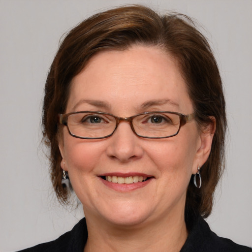 Joyful white adult female with medium  brown hair and blue eyes