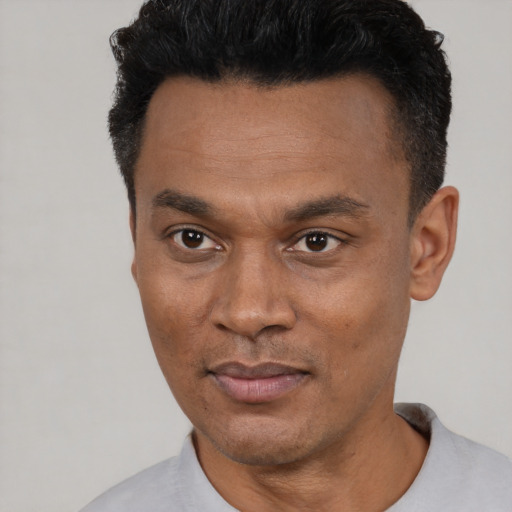 Joyful latino young-adult male with short  black hair and brown eyes