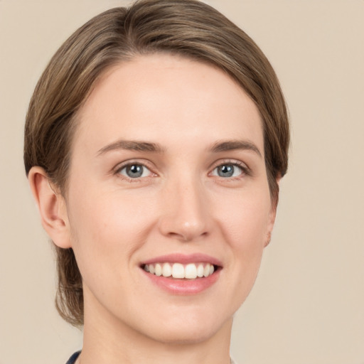 Joyful white young-adult female with medium  brown hair and grey eyes