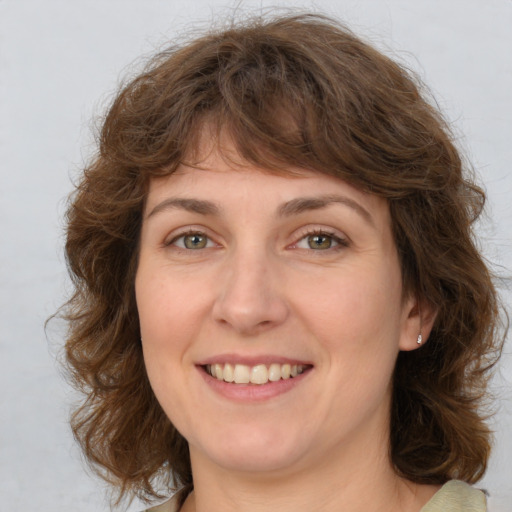 Joyful white young-adult female with medium  brown hair and green eyes