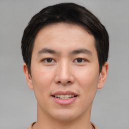 Joyful asian young-adult male with short  brown hair and brown eyes