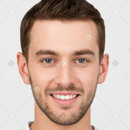 Joyful white young-adult male with short  brown hair and grey eyes