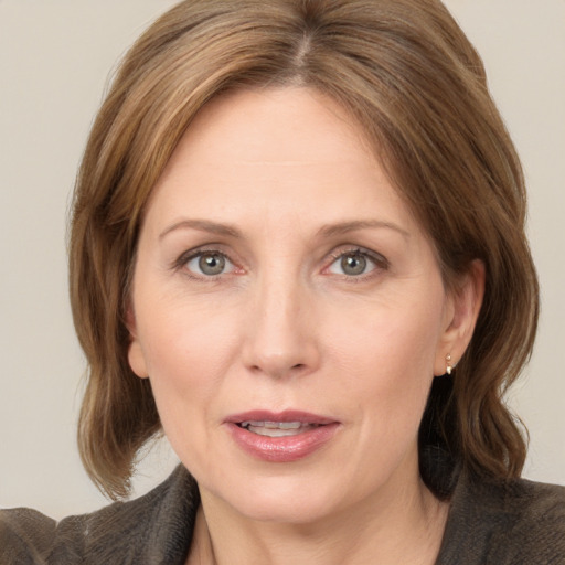 Joyful white adult female with medium  brown hair and grey eyes