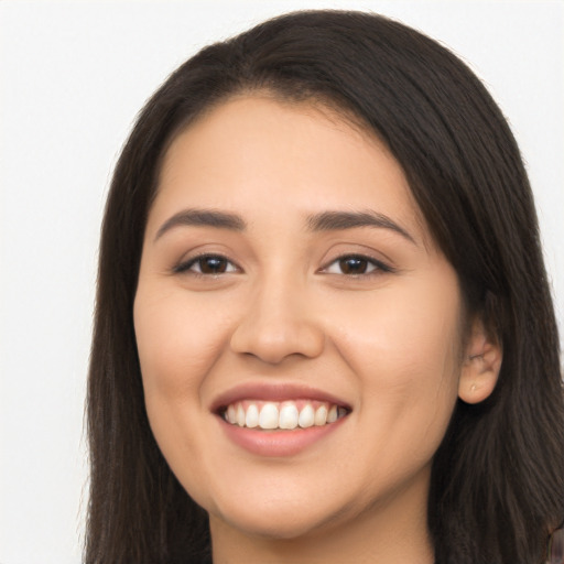 Joyful latino young-adult female with long  brown hair and brown eyes