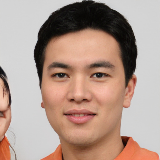Joyful asian young-adult male with short  black hair and brown eyes