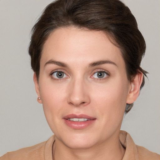 Joyful white young-adult female with short  brown hair and grey eyes