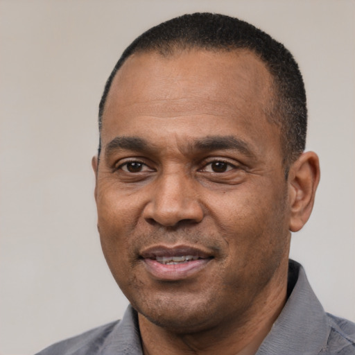 Joyful black adult male with short  black hair and brown eyes