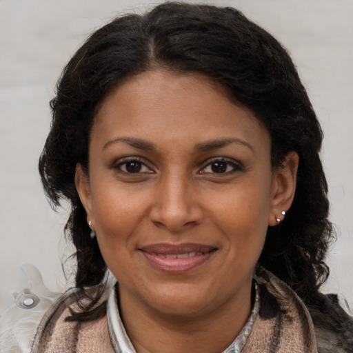 Joyful black adult female with long  brown hair and brown eyes