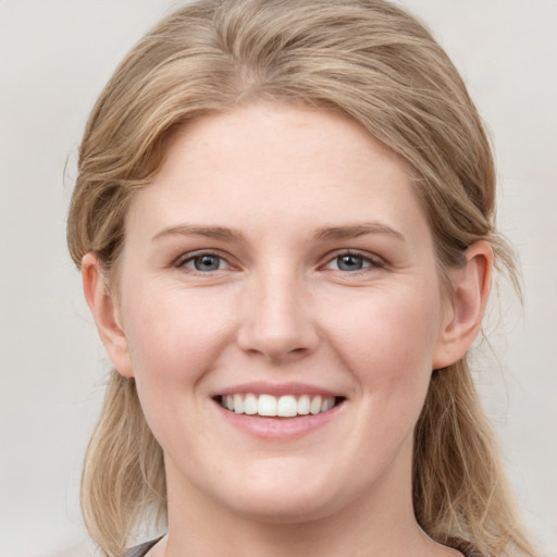 Joyful white young-adult female with medium  brown hair and blue eyes