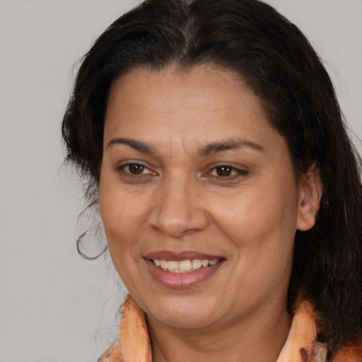 Joyful latino adult female with medium  brown hair and brown eyes