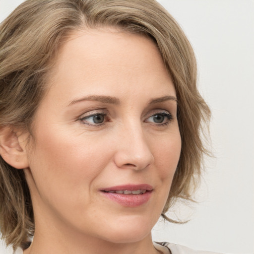 Joyful white young-adult female with medium  brown hair and green eyes