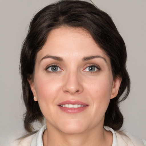 Joyful white young-adult female with medium  brown hair and green eyes