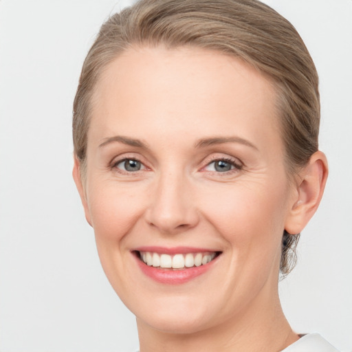 Joyful white young-adult female with short  brown hair and grey eyes